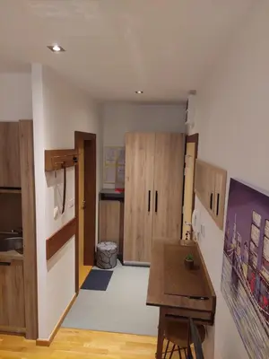 a kitchen with wooden cabinets and a wooden table at Brzeće Center Studio Mitrovski Gondola 300m in Kopaonik