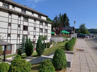 a building with a row of trees in front of it at Brzeće Center Studio Mitrovski Gondola 300m in Kopaonik