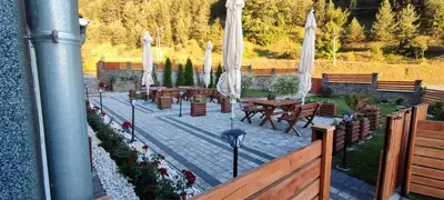 a patio with tables and white umbrellas at Vila Ivanović in Kopaonik