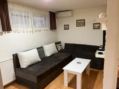 a living room with a black couch and a table at Čarapan in Kruševac