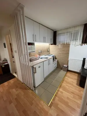 a small kitchen with white cabinets and a sink at Čarapan in Kruševac