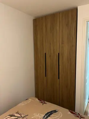 a bedroom with a wooden cabinet next to a bed at Čarapan in Kruševac