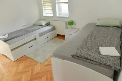 a bedroom with two beds and a window at Dobi Apartmani WING in Jagodina