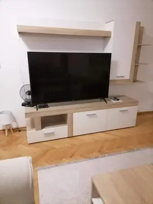 a flat screen tv on a stand in a living room at Dobi Apartmani WING in Jagodina