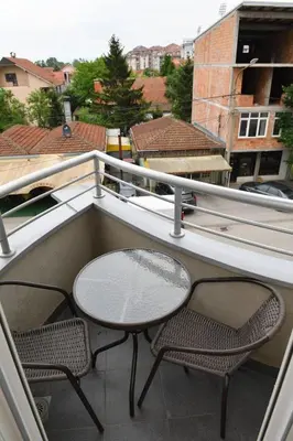 a patio with two chairs and a table on a balcony at Dobi Apartmani WING in Jagodina
