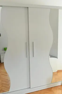 a pair of white cabinets in a living room at Dobi Apartmani WING in Jagodina