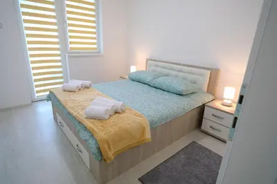a bedroom with a bed with towels on it at Apartmani Gorunović in Soko Banja