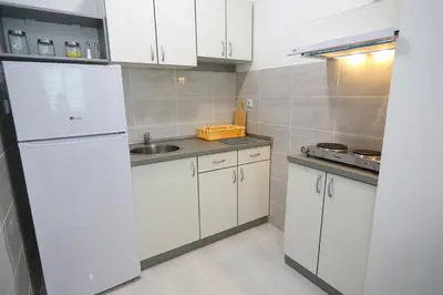 a white kitchen with a sink and a refrigerator at Apartmani Gorunović in Soko Banja