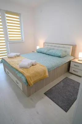 a bedroom with a bed with two towels on it at Apartmani Gorunović in Soko Banja