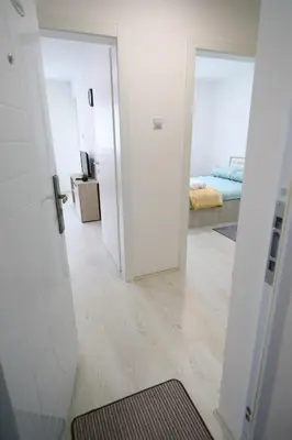 a room with a hallway with a bed and a mirror at Apartmani Gorunović in Soko Banja