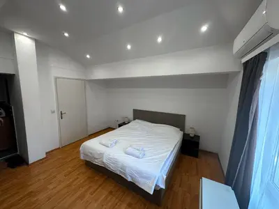a bedroom with a bed with white sheets on it at Mikasa in Niš