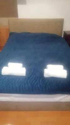 two lights on a bed with a blue blanket at Mikasa in Niš