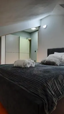 a large bed with two towels on top of it at Loft apartman in Jagodina