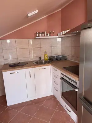 a kitchen with white cabinets and a sink at Loft apartman in Jagodina