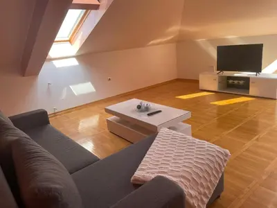 a living room with a couch and a tv at Loft apartman in Jagodina