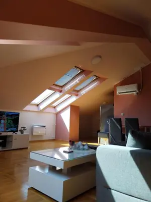 a living room with a couch and some skylights at Loft apartman in Jagodina