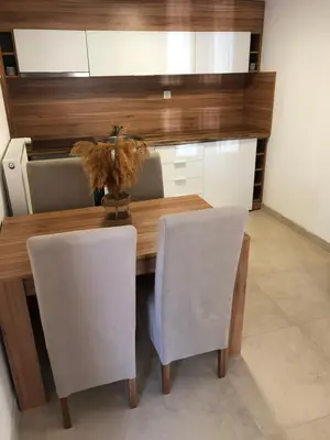 a dining room table with white chairs and a wooden table at Apartmani Tesla in Soko Banja
