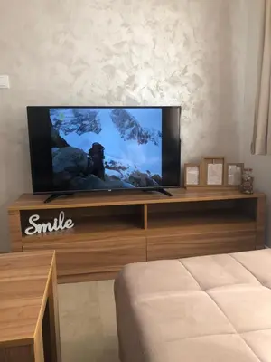 a flat screen tv sitting on top of a wooden entertainment center at Apartmani Tesla in Soko Banja