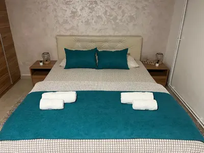 a bedroom with a bed with towels on it at Apartmani Tesla in Soko Banja