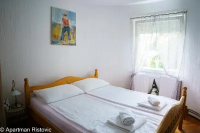 a bedroom with a bed with towels on it at Apartman Ristovic in Vrnjačka Banja