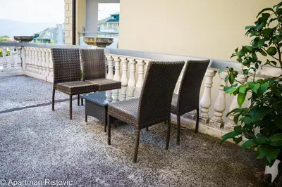 three chairs and a table on a balcony at Apartman Ristovic in Vrnjačka Banja