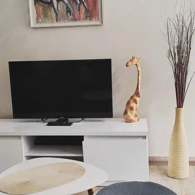a tv screen with a statue of a giraffe on a desk at Apartmani MIBOR in Vrnjačka Banja