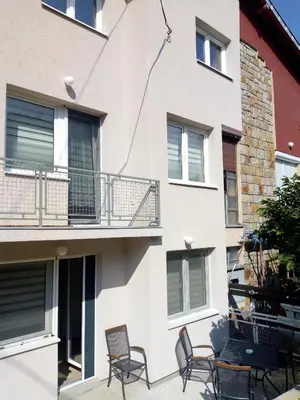 a apartment building with chairs and a balcony at Apartmani MIBOR in Vrnjačka Banja