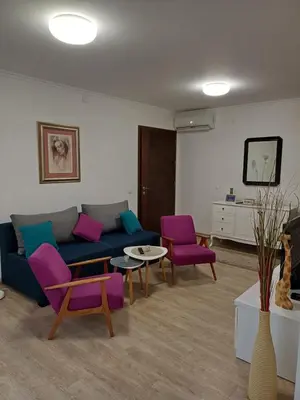 a living room with a blue couch and purple chairs at Apartmani MIBOR in Vrnjačka Banja