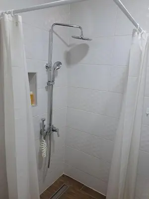 a shower with a shower curtain in a bathroom at Apartmani MIBOR in Vrnjačka Banja