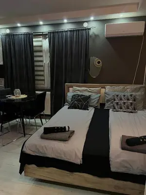 a bedroom with two beds and a table and a dining room at Beta House Apartments in Zaječar