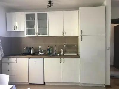 a kitchen with white cabinets and a sink at Apartman Djordjevići in Vrnjačka Banja