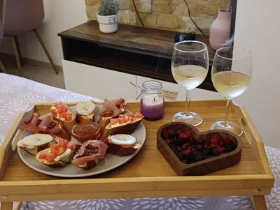 a tray with a plate of food and two glasses of wine at Snow peak Wellness & Spa, Kopaonik Milmari N5 in Kopaonik