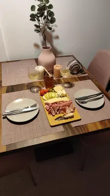 a table with a plate of food and wine glasses at Snow peak Wellness & Spa, Kopaonik Milmari N5 in Kopaonik