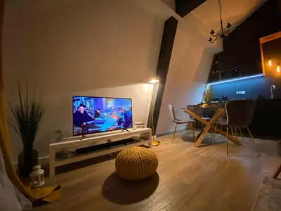 a living room with a television and a table with chairs at Apartman L8 Kopaonik in Kopaonik