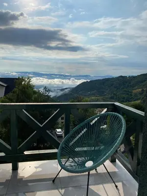 a green bench sitting on a balcony with a view at Apartman L8 Kopaonik in Kopaonik
