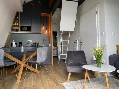 a kitchen and living room with a table and chairs at Apartman L8 Kopaonik in Kopaonik