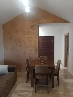 a dining room with a table and chairs and a couch at Kopaonik Jaram ski lift slope Karaman in Kopaonik