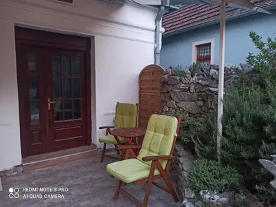 two chairs and a table on a patio at Apartmani Lina in Ribarska Banja