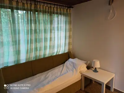 a bed in a room with a window and a table at Apartmani Lina in Ribarska Banja
