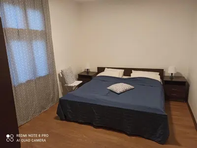 a bedroom with a bed with a blue blanket at Apartmani Lina in Ribarska Banja
