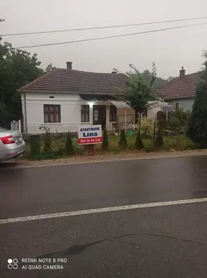 a white house with a sign in front of it at Apartmani Lina in Ribarska Banja