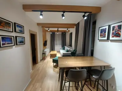 a living room with a wooden table and chairs at Apartman Djordje-vila Montana in Kopaonik