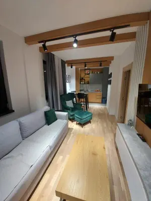 a living room with a white couch and a table at Apartman Djordje-vila Montana in Kopaonik