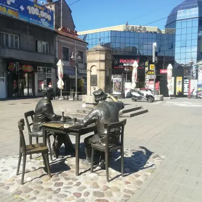 a statue of two people sitting at a table at suvi centar in Niš