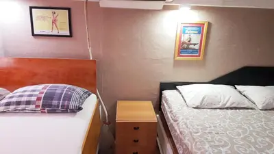 a small bedroom with two beds and a night stand at suvi centar in Niš