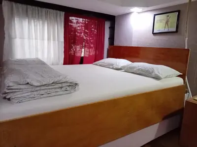 a bed with white sheets and pillows in a room at suvi centar in Niš