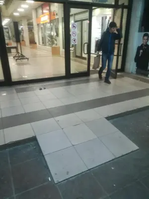 a person walking in a building talking on a cell phone at suvi centar in Niš