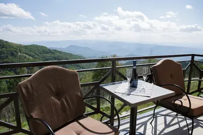 a table and chairs on a balcony with a view at Dvori Sky View E13 Kopaonik - free private parking in Kopaonik