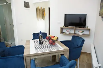 a dining room with a table and blue chairs at Dvori Sky View E13 Kopaonik - free private parking in Kopaonik