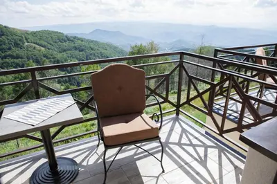 a chair sitting on a balcony with a view at Dvori Sky View E13 Kopaonik - free private parking in Kopaonik